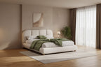 Cama tapizada Brady con tela de lino, cabecero de diseño curvo y patas de madera maciza